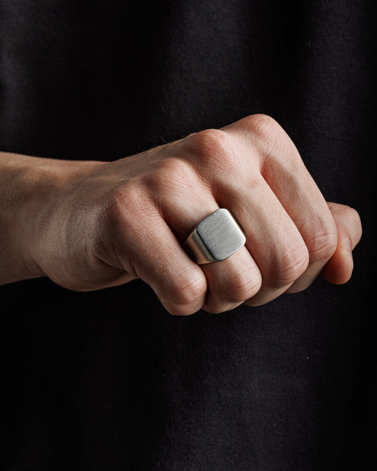 Silberner Siegelring am Finger eines Mannes